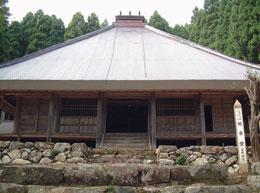 山に囲まれた明隆寺観音堂を正面から撮影した写真