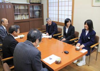 町長室のテーブルに、平田有真さん、町長、関係者の6名が座り、笑顔で談笑している写真