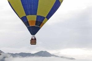 黄色と青色の四角が交互色付けされた模様の気球が上空を飛んでいる写真