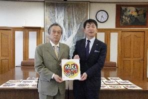 伊澤史朗町長(左)と太田昇町長(右)がだるまの絵を持って並んで写っている写真