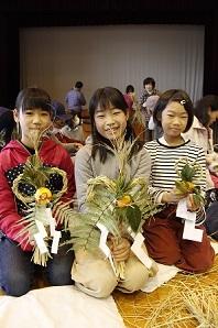 女子児童3名が手作りのしめ縄を手に持って笑顔で写っている写真