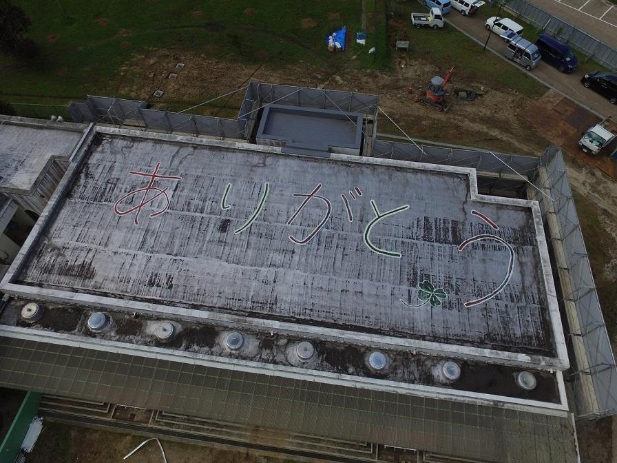 令和2年7月31日の工事着手前、既存園舎上空から撮影した写真。旧園舎の屋上に「ありがとう」の文字がかいてある写真。