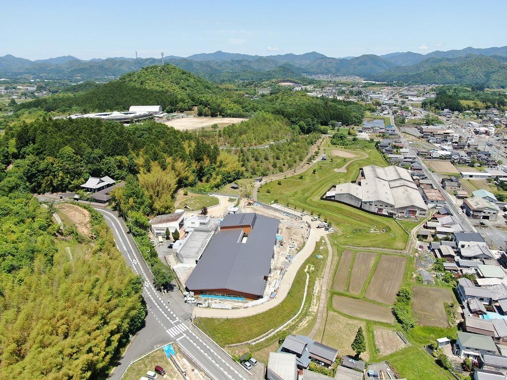 令和3年5月31日の工事進捗、南東から撮影した写真。グレーの屋根と茶色い外壁の新園舎の内装外装、外構工事を施工している状況の写真。