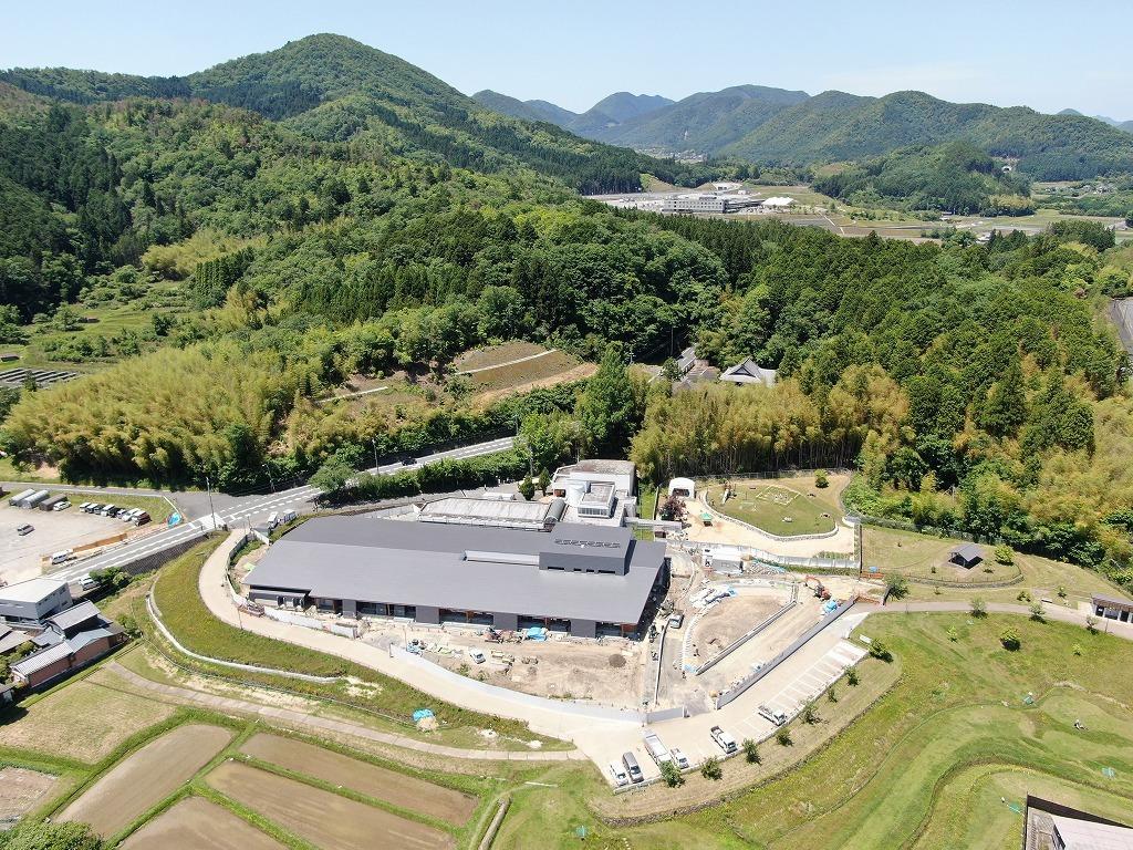 令和3年5月31日の工事進捗、東から撮影した写真。グレーの屋根の建物の周囲の外構工事を施工している状況の写真。