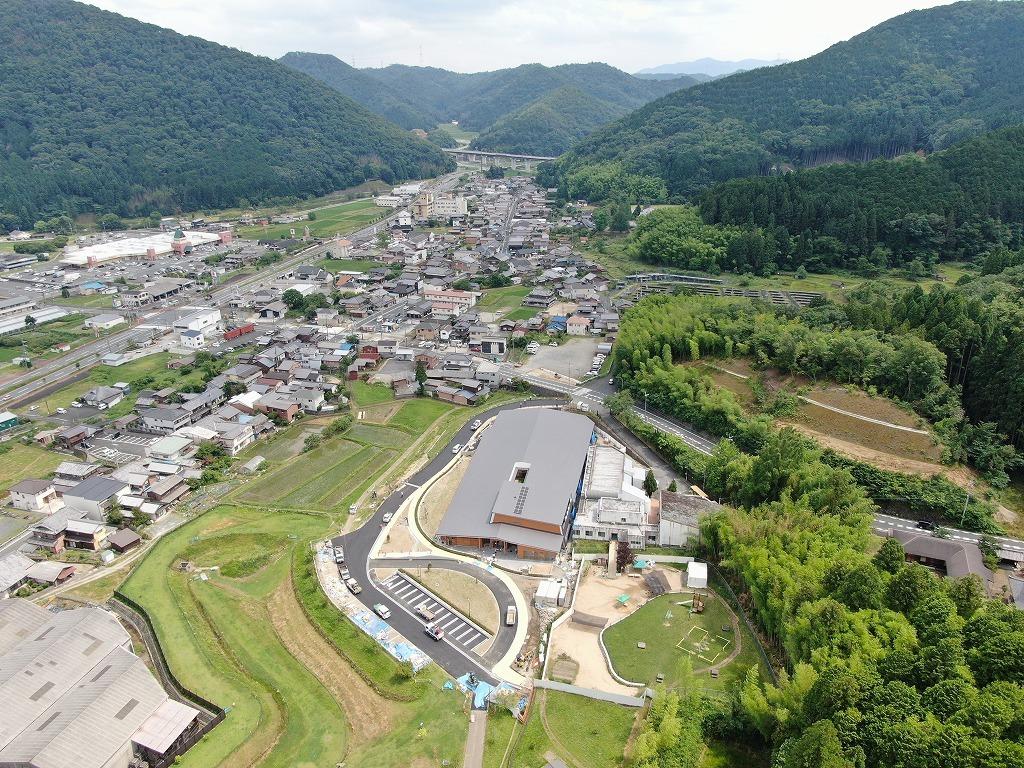 令和3年6月30日の工事進捗、北から撮影した写真。建物の周囲に数台のトラックがとまっている状況の写真。