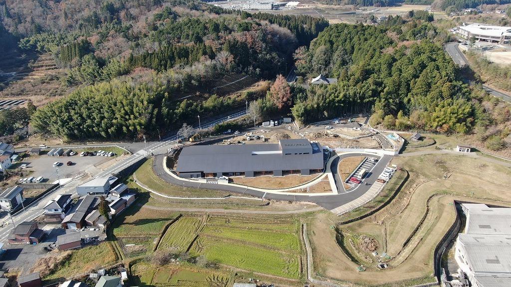令和3年12月3日の工事進捗、東から撮影した写真。建物の裏で外構工事がすすめられている状況の写真。