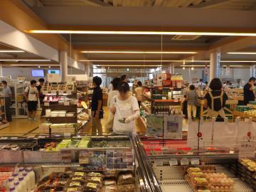 商品棚に沢山の商品が置かれ、お客さん達が買い物をしている道の駅「京丹波味夢の里」の店内写真