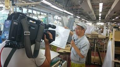商品の説明をしている町内企業の社員の方と、その様子を撮影しているケーブルテレビのカメラマンの写真