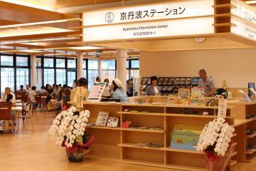 パンフレットが置かれた棚の前に胡蝶蘭が飾られた京丹波ステーションの写真
