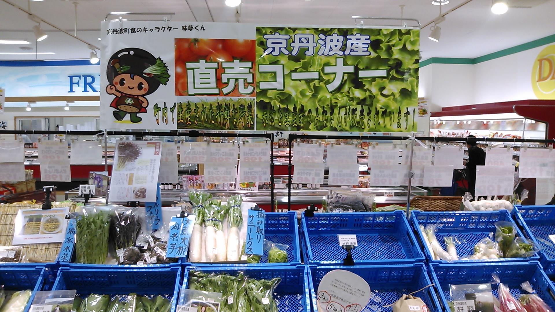 京丹波産直売コーナーと書かれ、青いかごに野菜並べられ、販売されている写真