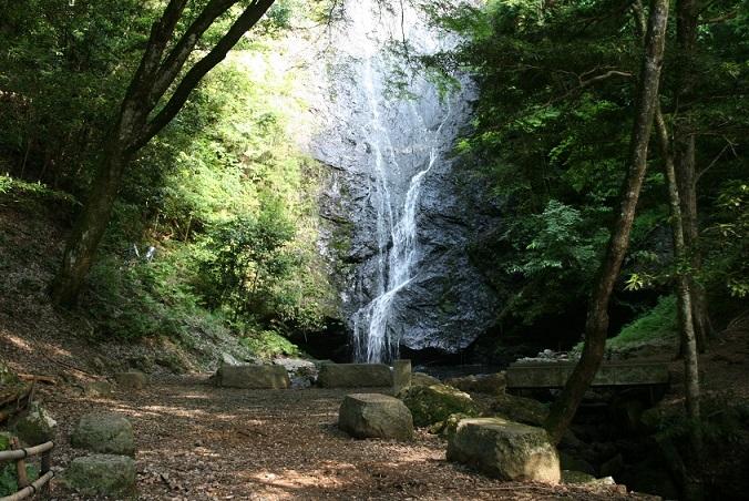 両脇は木々に囲まれ、大きな岩を白糸のように水が流れ落ちている琴滝の写真