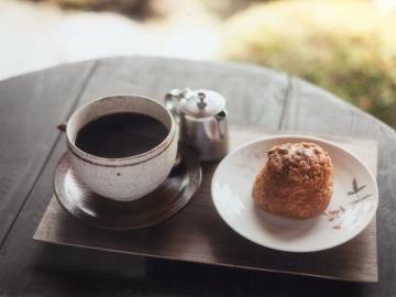 テーブルの上にコーヒーと焼き菓子が置かれている写真