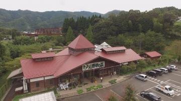 赤い屋根のわち山野草の森の建物全体と駐車場を上空から撮影した写真