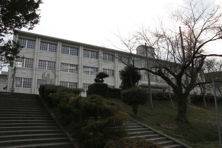 階段を登った場所に3階建ての白い外壁の校舎が見える瑞穂中学校の外観写真