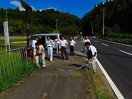 歩道の距離をメジャーで計っている現地調査の様子の写真