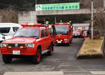 赤色の消防団の車両が次々と通りに出て来きて、啓発パレードに出発する様子の写真