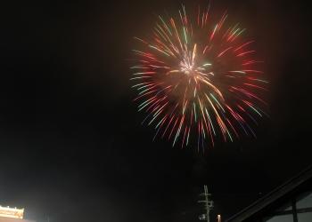 夜空に打ち上げられた、赤や黄色、緑、オレンジなど色鮮やかな大輪の花火の写真