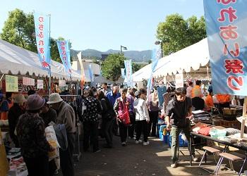 わちふれあい祭りの登り旗が建てられ、いろいろなお店のテントが並んでおり、沢山のお客さんでにぎわっている様子の写真