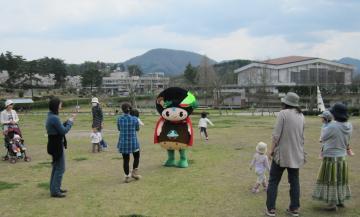 広場の中に味夢くんが立っており、周囲に親子が集まって来ている写真