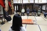 お寺の畳の敷かれた和室に、僧侶と参加者の方々が向かい合って椅子に座っている写真