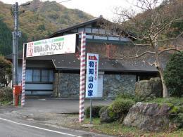 赤と白の縞模様の柱の間に「ようこそ」という文字が書かれた横断幕が張られている京都府青少年和知山の家の入口の写真
