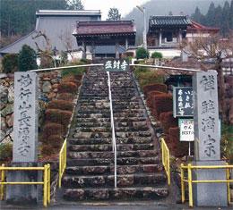 中央に「長源寺」と書かれた看板と長源寺へ続く階段があり、その左側に「妙行山長源寺」と彫られた石碑、右側に「禅臨済宗」と彫られた石碑が建っている写真