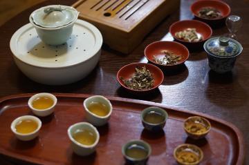 様々な種類のお茶と、小皿に乗っている茶葉の写真