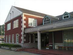 茶色い外壁で上部に白枠の正方形の窓が2つ、下部に白枠の長方形の窓が4つある、京丹波町健康管理センターの写真