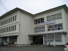 白い外壁で3階建て、入り口の上部に看板が掲げられている京丹波町中央公民館の建物の写真