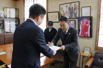 大塚会長が太田町長へ答申書を手渡ししており、佐藤副会長が後方に立ち頭を下げている写真